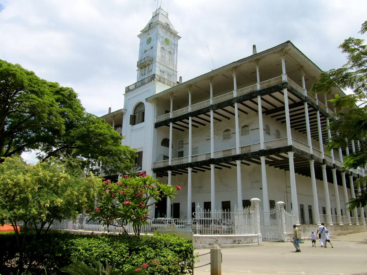 House of Wonders clock tower and verandas seen from a green garden