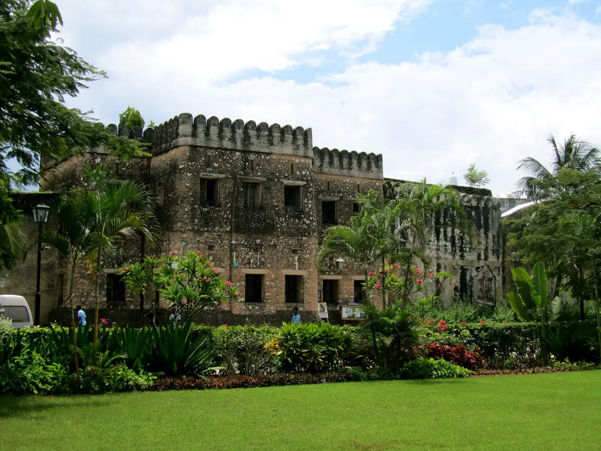Old Fort of Zanzibar with crenellated walls behind a green lawn