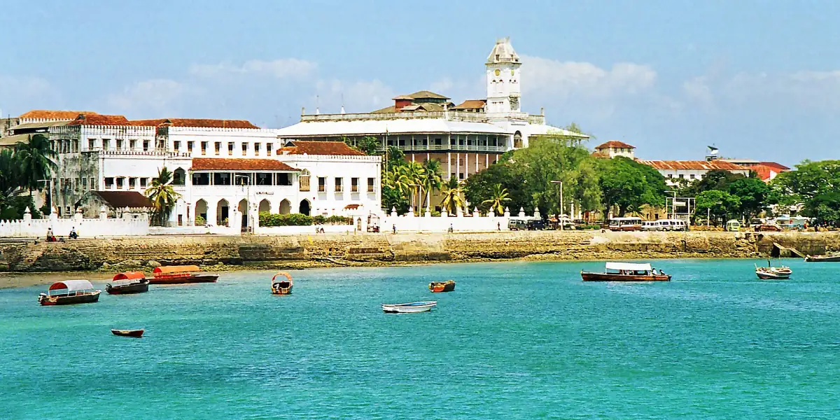 Front de mer de Stone Town avec le House of Wonders et des bateaux sur une eau turquoise