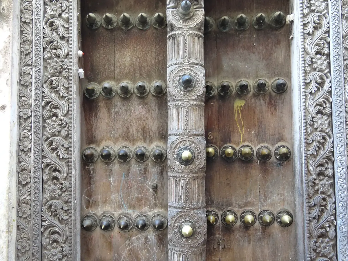 Detail of a carved wooden door with brass studs in Stone Town